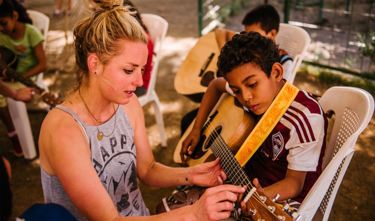 A young student in Nicaragua learning to play guitar.